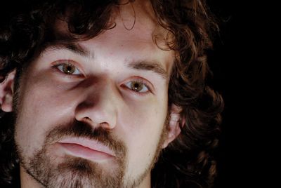 Close-up portrait of man against black background