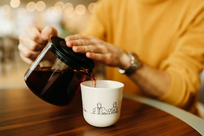 Midsection of coffee cup on table