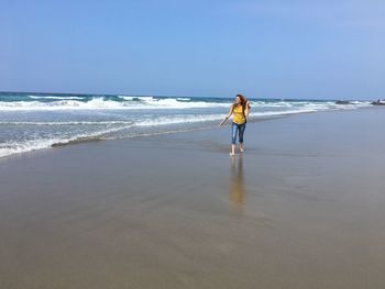 Full length of woman walking on shore at beach