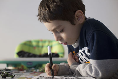 Boy drawing in book at home