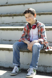 Boy sitting on steps outdoors