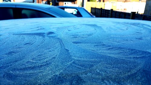 Close-up of blue car in city