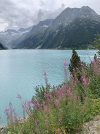 Scenic view of lake by mountains against sky