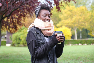 Portrait of woman wearing sunglasses standing in park during winter