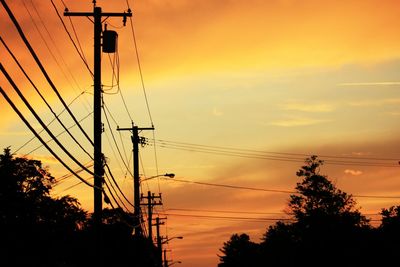 Low angle view of silhouette electricity pylon against romantic sky