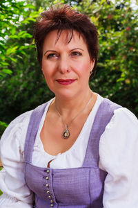 Close-up of smiling mature woman against plants