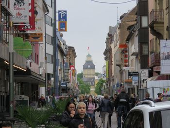 People on street amidst buildings in city