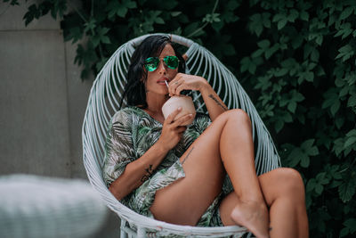 Midsection of woman holding while sitting in water