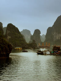 Scenic view of river by mountains against clear sky