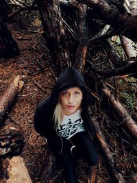 Portrait of young woman standing on field in forest