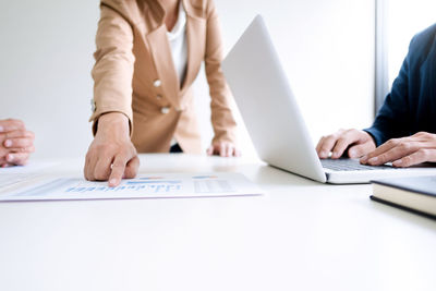 Midsection of woman using laptop on table