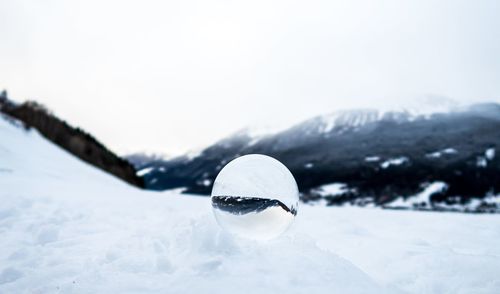 Close-up of snow on field against sky