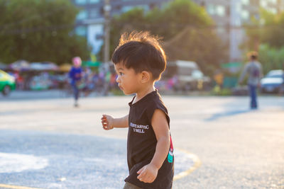 Side view of boy standing outdoors