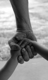 Cropped hands of family at beach