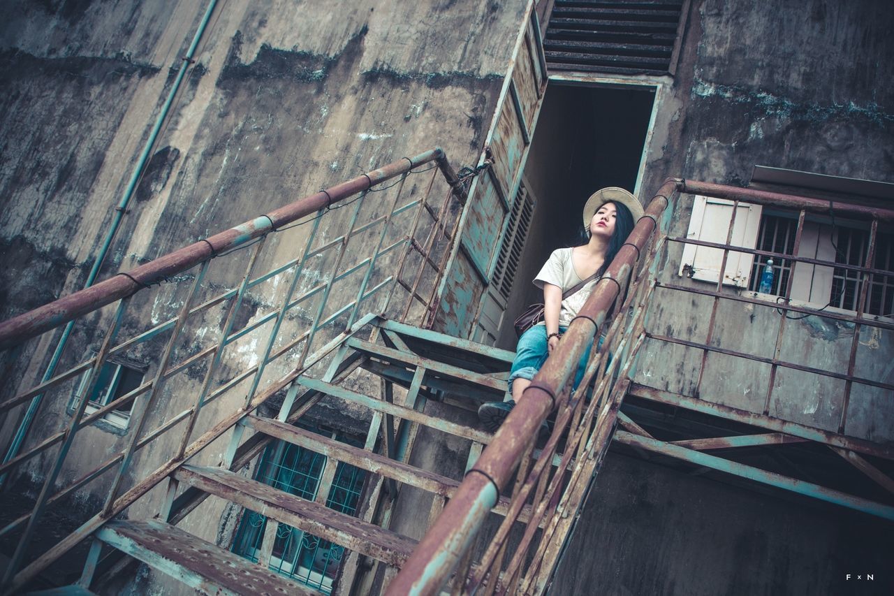 WOMAN STANDING IN FRONT OF BUILDING