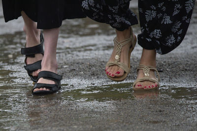 Low section of woman standing on wet floor during rainy season