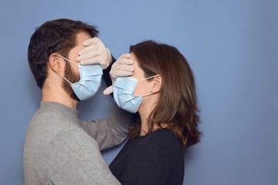 Portrait of couple kissing against white background