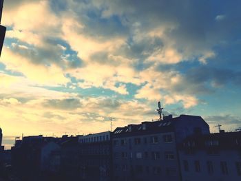 Low angle view of buildings against cloudy sky