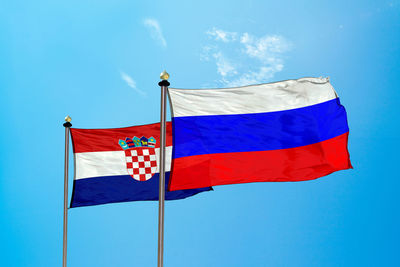 Low angle view of flag flags against blue sky