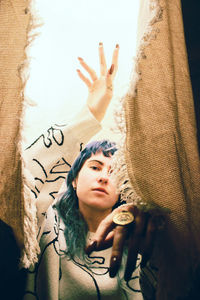 Portrait of beautiful young woman amidst burlap