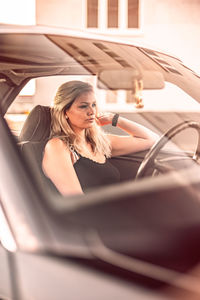 Beautiful woman sitting at car