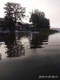 Scenic view of lake by buildings against sky