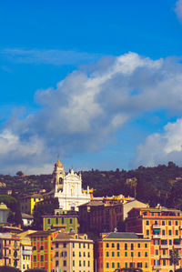 Buildings in city against cloudy sky