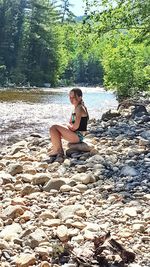 Woman sitting on rock in forest