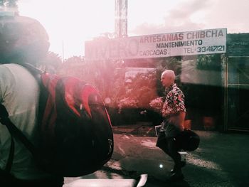 People standing on street in city against sky