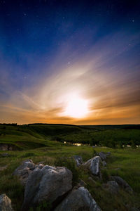 Natural moon halo at starry night in summer scenic green landscape