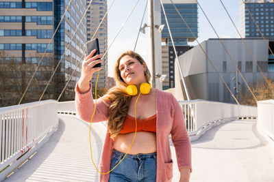 Young woman taking selfie through smart phone