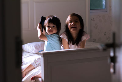 Siblings looking at camera at home