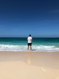 Rear view of man standing at beach