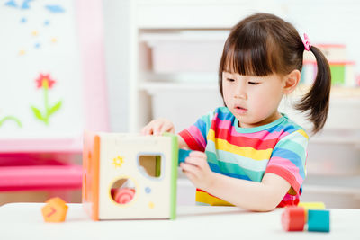 Young girl playing number shape blocks for homeschooling
