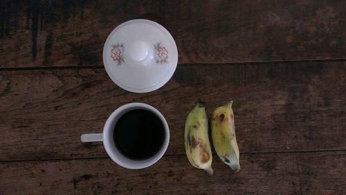 High angle view of black tea and bananas on table