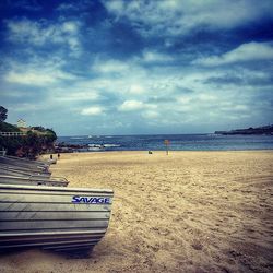 Scenic view of beach against cloudy sky