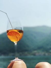 Close-up of beer glass against sky