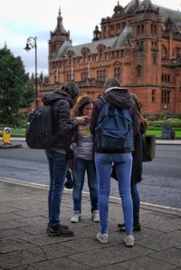 Rear view of friends walking in front of building