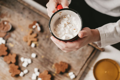 A cup of cocoa with marshmallows close-up, against the backdrop of christmas cookies.