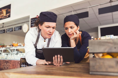 Female owners using digital tablet in grocery store