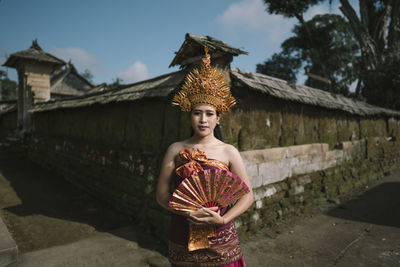 Full length of woman standing against building