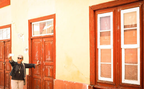 Man standing against door of building