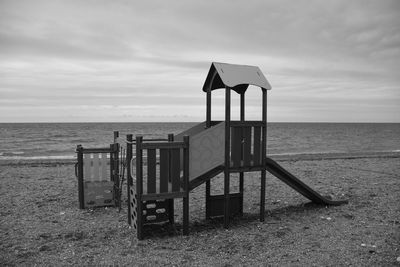 Lifeguard hut on beach against sky