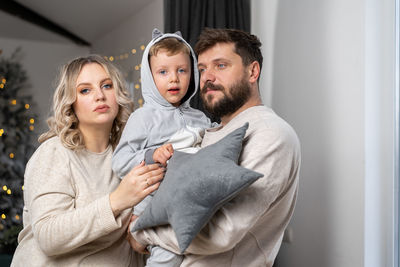 Portrait of mother and son with father standing home