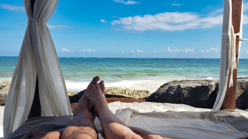 Low section of woman relaxing at beach