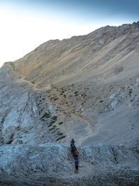 Full length of person on rock in mountains against sky