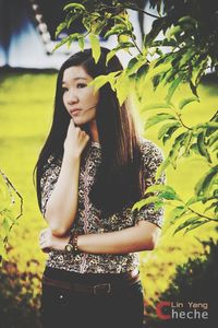 Beautiful young woman standing against plants