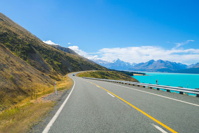 Road leading towards mountains against sky