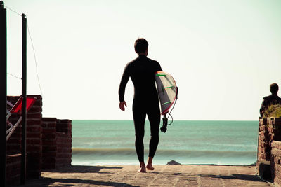 Rear view of man looking at sea against sky