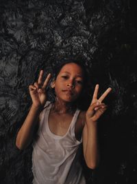 Portrait of young woman against black background